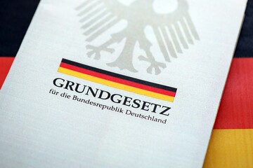 The constitution basic law book of Germany lies on Germany flag background close up