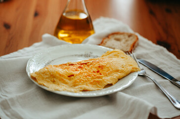 Cheese omelet with rustic bread and olive oil served on white tablecloth