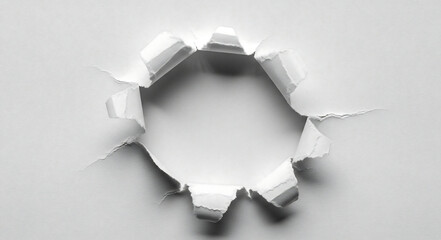 A white sheet of paper with a hole in the middle showing a bright white light behind the paper sheet