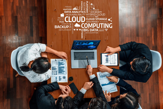 A diverse team meets around a conference table to discuss cloud computing strategies using data analytics, showcasing modern technology and collaborative planning. Amity