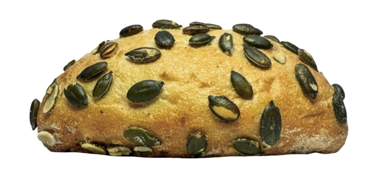 Freshly baked pumpkin seed bread roll. Artisan bakery product for a healthy breakfast. Close up detail of a whole grain bun with seeds. Nutritious food and wholesome diet concept