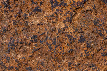Close-up view of rough, textured brown and dark-brown rusted iron.