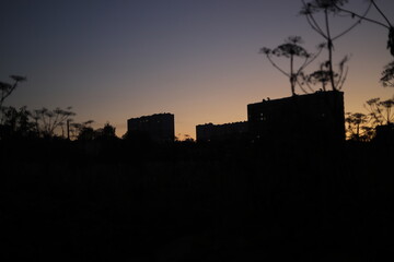 The silhouette of the city on the horizon. The city at night. Buildings stand in the dark.