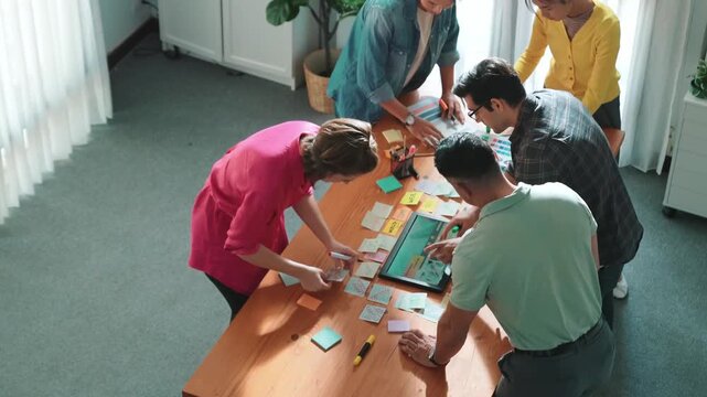 Time lapse of manager writing idea on sticky note and explain idea about web design. Professional marketing team or programmer brainstorming idea while looking at tablet with color palette. Symposium.