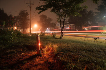 Smart Sensor Mast Logging Infiltration At Median Rain Garden At Night, LED Indicator And Solar Node, Bicycle Light Trails