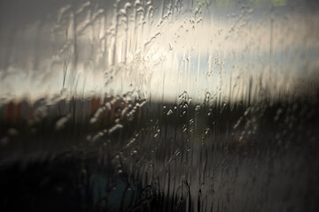 Wet glass. Jets of rain on the glass. Spray on the window. Rain on the street.