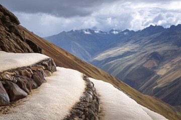 High-Andean Quinoa Terraces After Hailburst, White Pellets Along Stone Risers, Rainbow Remnant, Elevated Drone Perspective