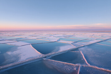 Partially Frozen Salt Evaporation Ponds At Blue Hour, Geometric Crystallization Patterns, Overhead Aerial Near Baltic Coast