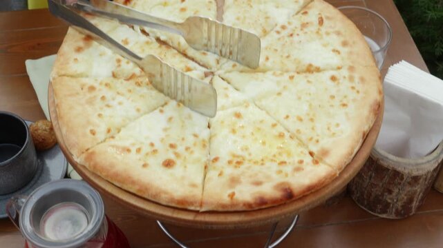 Traditional Georgian cuisine featuring grilled kebab and khachapuri cheese bread, freshly served on rustic wooden surface inside restaurant dining environment
