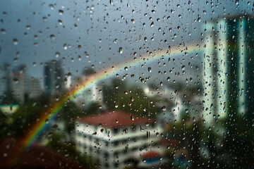 Equatorial Monsoon City Balcony Photovoltaics With Raindrops And Faint Rainbow Over Rooftops, Focus-Pull Look, Afternoon Downpour