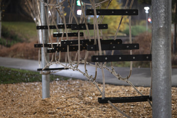 Empty rope bridge at playground in evening light &mdash; modern outdoor play equipment symbolizing childhood, balance and adventure
