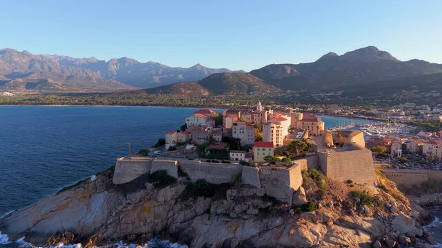 Aerial view of calvi citadel at sunrise with serene waters. Fortress with marina. Corsica. France