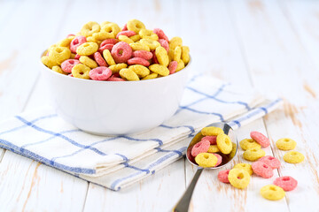 corn rings and strawberry rings in a ceramic bowl on a white wooden table, selective focus.