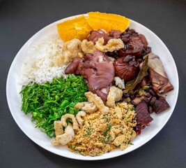 The best and most traditional  Brazilian feijoada, with rice, farofa, cabbage, orange, cracklings. Dish symbol of Brazil