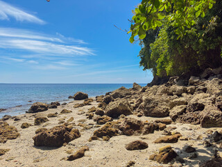 Stunning tropical beach with rocks and clear blue sky invites you to relax and unwind