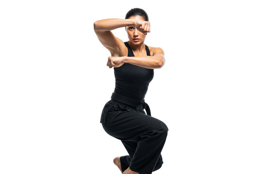 Female martial artist with a black belt in a dynamic fighting pose