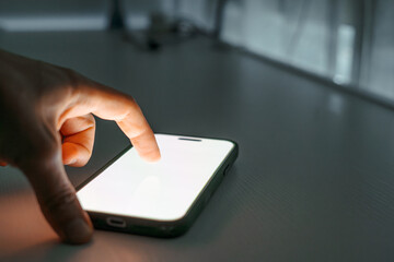 Finger touching smartphone screen closeup