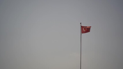 Turkish flag is fluttering on the flagpole in the wind. Turkish national flag. 