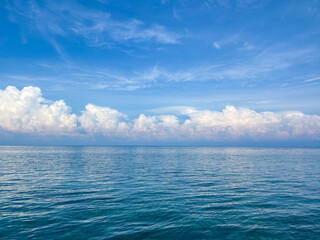 Vibrant blue ocean meets dreamy cloudscape horizon for captivating tropical travel inspiration