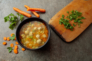 Obraz premium Classic meatball soup with potatoes, carrot and greens.
