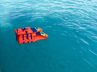 Vibrant orange life vests floating peacefully on tranquil turquoise ocean water beckoning adventure and safety