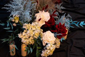 Elegant wedding table floral arrangement with fresh roses, peonies, and greenery. Romantic centerpiece decoration for a wedding reception or banquet, featuring soft pastel colors and delicate blooms c