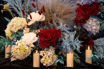 Elegant wedding table floral arrangement with fresh roses, peonies, and greenery. Romantic centerpiece decoration for a wedding reception or banquet, featuring soft pastel colors and delicate blooms c