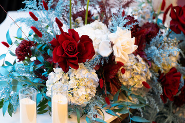 Elegant wedding table floral arrangement with fresh roses, peonies, and greenery. Romantic centerpiece decoration for a wedding reception or banquet, featuring soft pastel colors and delicate blooms c