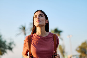 Portrait of a smiling young woman girl walking in the city, tourists visiting destination, summer trip exploring