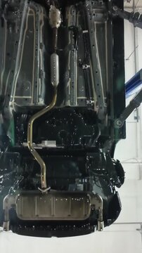 Vehicle inspection overview, Clean chassis and components inspection, Automotive maintenance with thorough underbody examination, Car lifted for detailed undercarriage inspection and cleanup