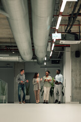 Diverse business people walking talking in modern office hallway