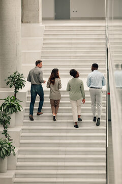 Diverse business team walking up office stairs