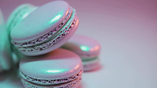 Iridescent macarons stacked in artistic arrangement under colorful light. concept of vibrant dessert art, stylish confectionery, gourmet indulgence