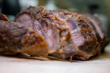 Delicious well-done roast beef, sliced on a cutting board. Selective focus on the tender meat texture, with a blurred foreground and background.