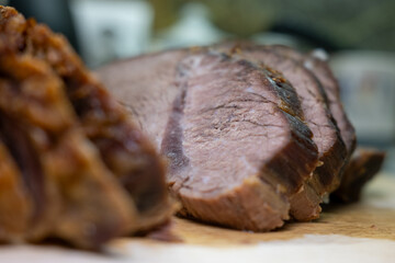 Delicious well-done roast beef, sliced on a cutting board. Selective focus on the tender meat texture, with a blurred foreground and background.