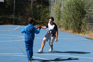 Young boy learning basketball from older brother on court