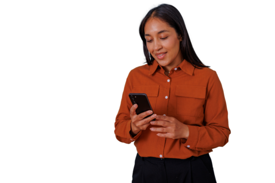 Young woman smiling, looking down, and using a mobile phone, texting, scrolling, or browsing social media apps