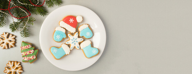 Christmas gingerbread on the white plate on a gray background. Top view. Copy space.