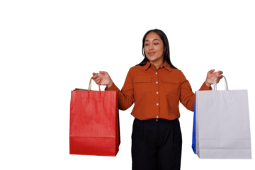 Young woman carrying various shopping bags, smiling and enjoying the experience, expressing satisfaction with her consumer choices. Transparent background