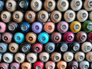 A background of colorful spray cans. Spray cans of graffiti paint.