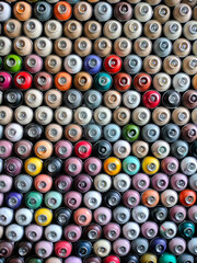 A background of colorful spray cans. Spray cans of graffiti paint.