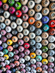 A background of colorful spray cans. Spray cans of graffiti paint.