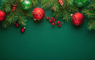Merry Christmas and Happy Holidays greeting card, frame, banner. New Year. Noel. Red Christmas ornaments on green background top view. Winter xmas holiday theme. Christmas tree decoration.
