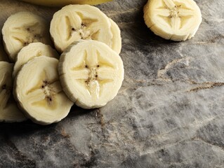 A sliced banana on the stoned board.