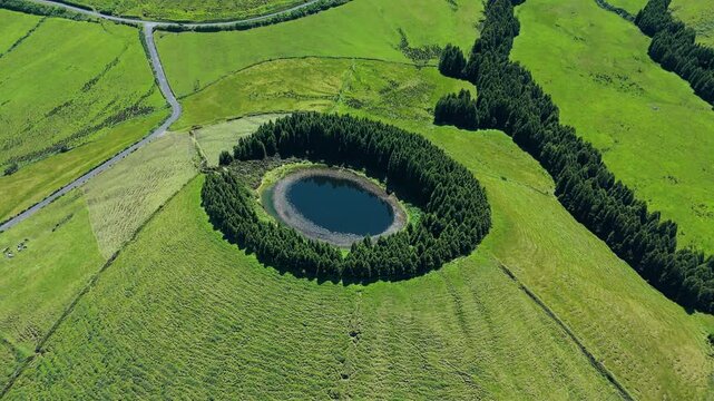 Scenic high angle drone view of round Lagoa Pau Pique in caldera in lush Azores landscape. Aerial view