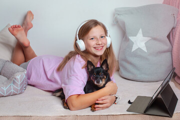 Smiling girl hugging Chihuahua on fluffy carpet
