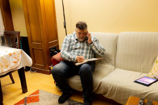 Man multitasking working from home talking on phone - Powered by Adobe