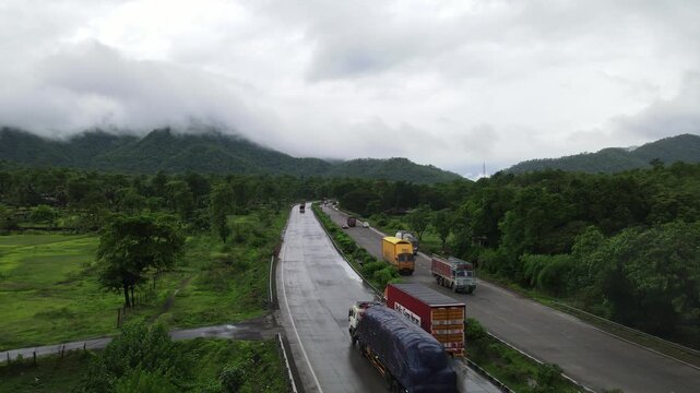 Aerial view of the Mumbai-Nagpur Expressway, also known as Samruddhi Mahamarg, captured during the monsoon season. The modern highway stretches through lush green landscapes, rain-soaked fields.