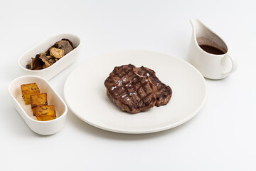 Juicy grilled beef steak served with sauce and sides