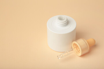 Minimalist white cosmetic dropper bottle on beige background. Elegant mockup for skincare, serum, or beauty branding presentations.